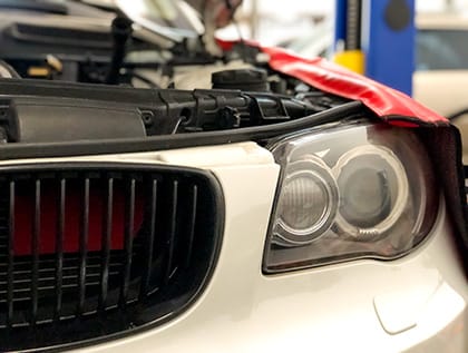 Front corner of white BMW 1 series with hood open